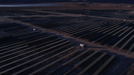 Aerial-View-of-Solar-Power-Plant-at-Sunset,-Solar-Panels-Arrays-in-Desert-Landscape