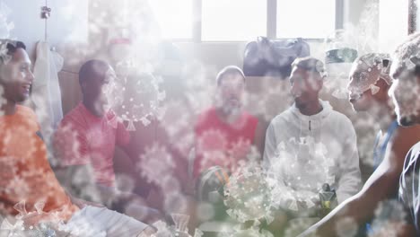 animation of virus cells over diverse male rugby players talking in changing room