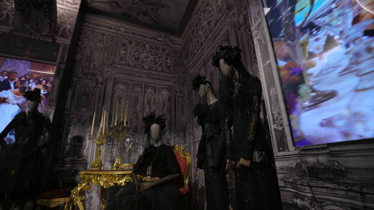 Gothic-inspired fashion display with mannequins in an ornate, dark exhibition space