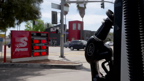 manija de la bomba de gas con signo de precio de gas en segundo plano