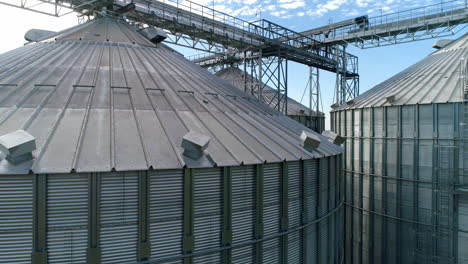 large silver granary. modern grain elevators. metal industrial silos for agribusiness. new plant for storing crop. close-up. drone view.