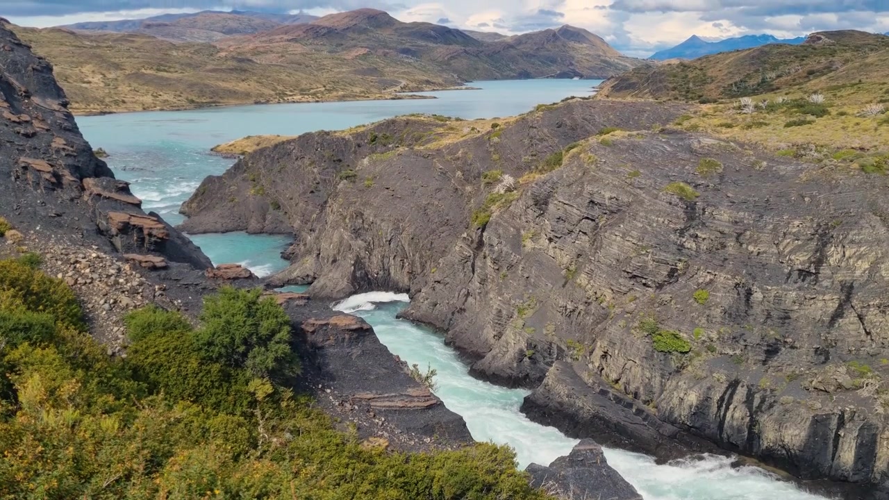 Fiume che collega il Lago Nordenskjöld e il Lago Pehoé nel Parco Nazionale Torres del Paine, Cile, circondato da un paesaggio aspro e dalla natura selvaggia incontaminata della Patagonia.