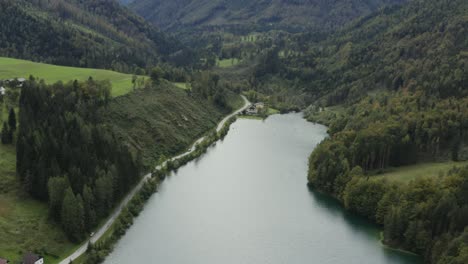 freibach reservoir dam in austria with some farm houses near the south shore, aerial dolly out reveal shot