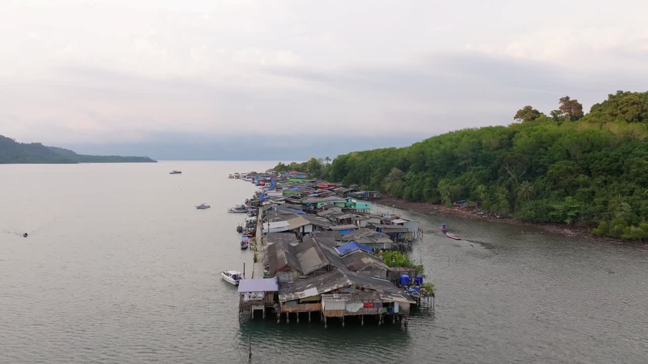 Pemandangan udara perahu yang melintasi perairan tenang dekat Dermaga Ao Salat saat matahari terbenam, Koh Kood