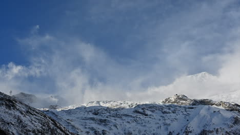 timelapse: a moving cloudy sky in the swiss alps over snowy mountains during the day, saas fee