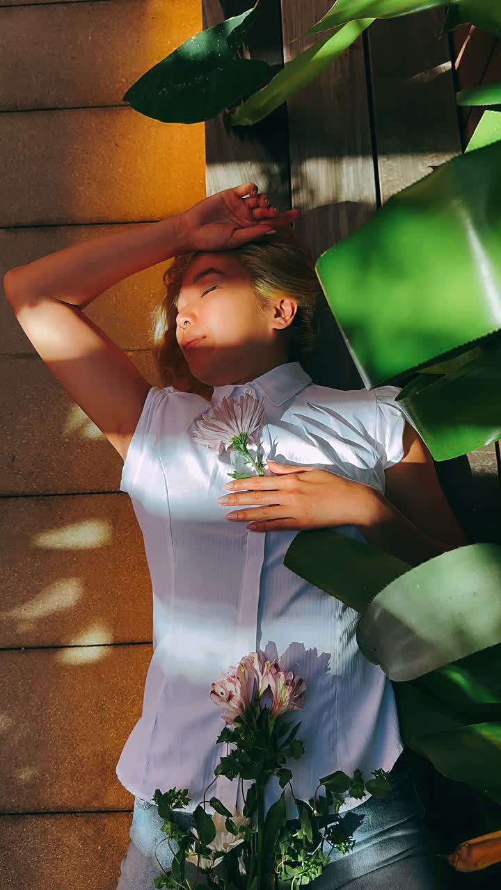 mujer relajándose entre las flores en el jardín