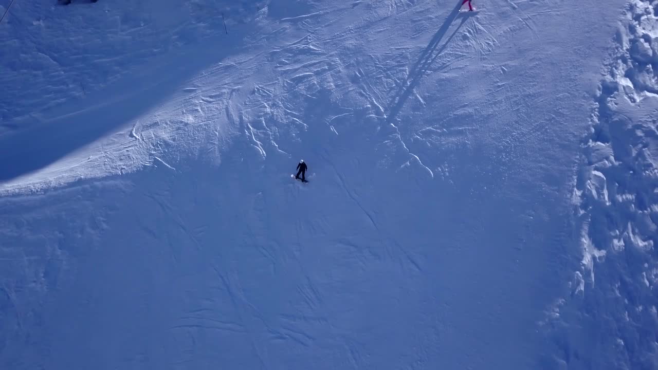드론이 프랑스 알프스 산맥의 토렌에서 스노우보더에 초점을 맞추고 날고 있습니다.