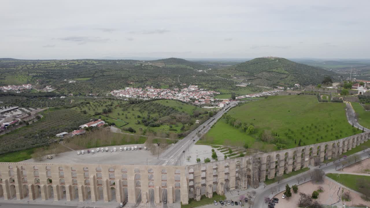 historic Amoreira Aqueduct spanning landscape in Elvas Portugal - aerial reveal