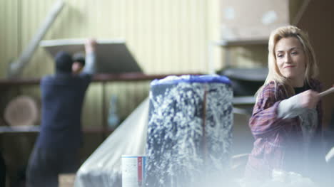 woman spraying paint on tree stump