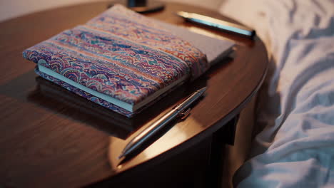 bedside table with notebook and pen
