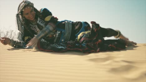 Gypsy-woman-rolling-on-a-desert-sand-dune