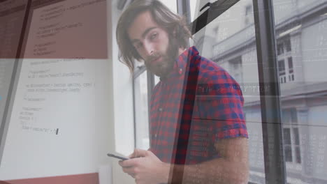 In office, man using smartphone with programming code and animation overlay