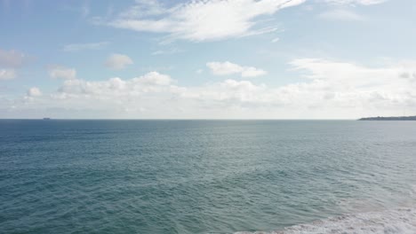 Levantándose-De-La-Vegetación-Costera-Verde-Con-Olas-Rompiendo-En-La-Playa-De-Tangalle