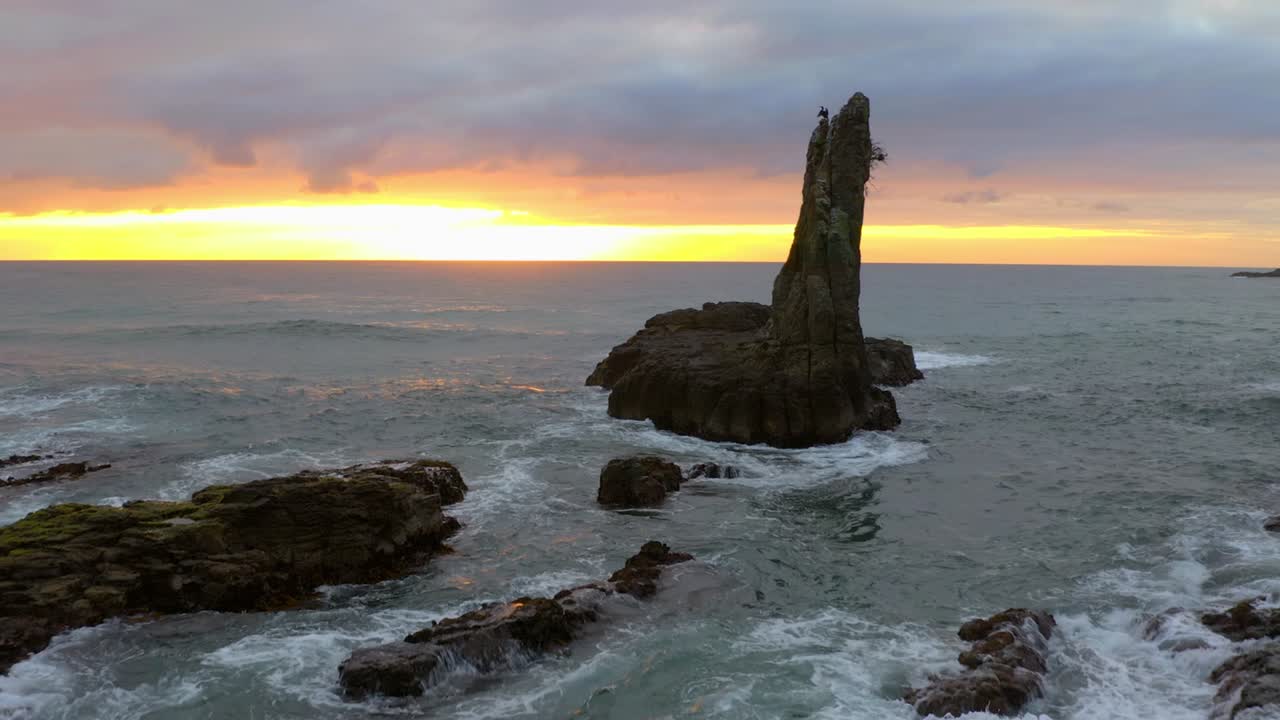las olas del mar salpican las pilas de mar y las rocas de la catedral durante la hora dorada en nueva gales del sur, australia