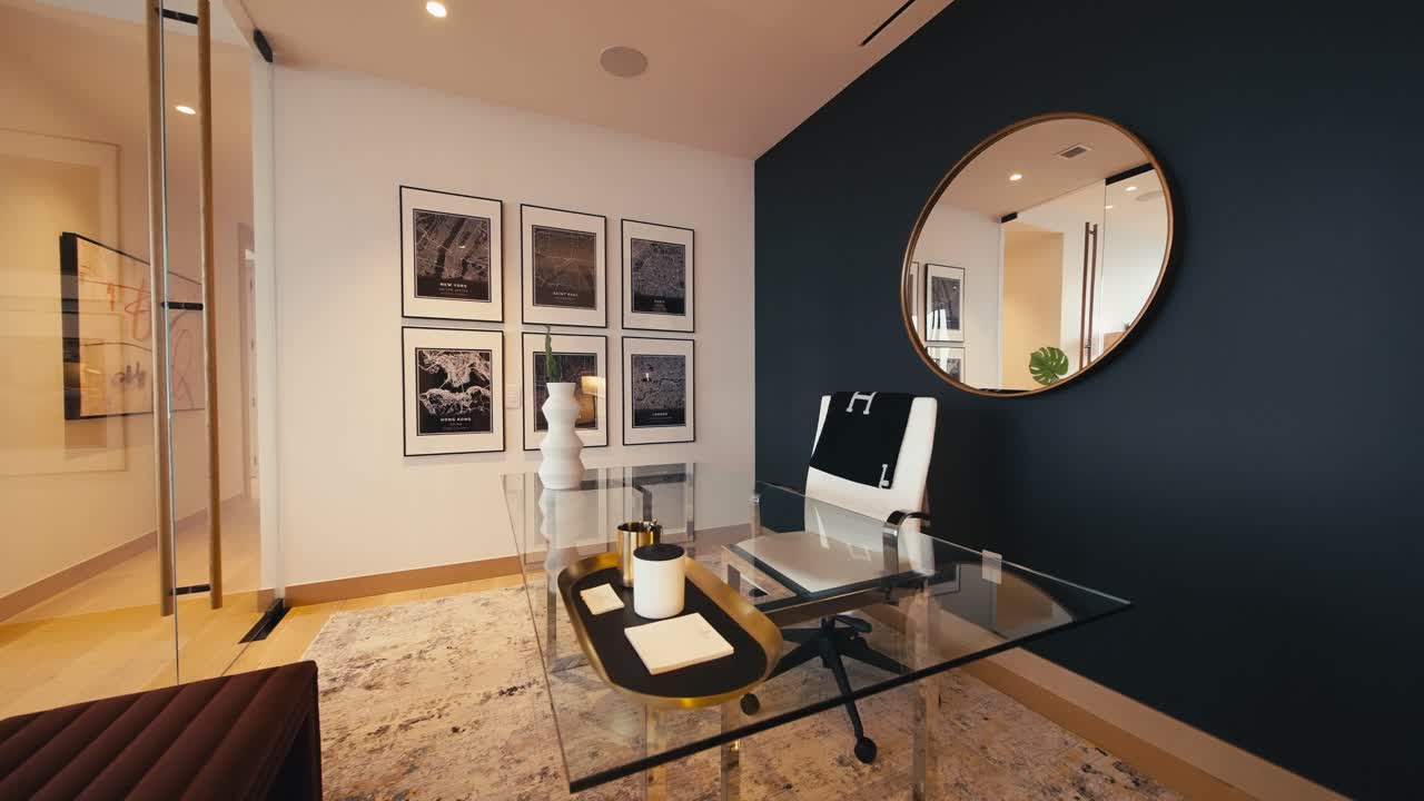 ampia spinta in una foto di un moderno ufficio a casa con un tavolo di vetro, una sedia bianca, uno specchio e l'arte appesa alla parete