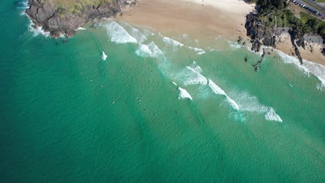 surfers in coral sea at norries cove in cabarita beach, new south wales, australia