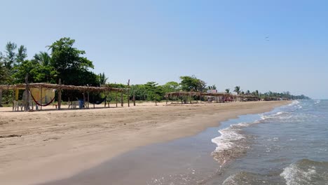 Empty-palapas-and-hammocks-in-a-tropical-beach-in-Mexico,-view-from-sea