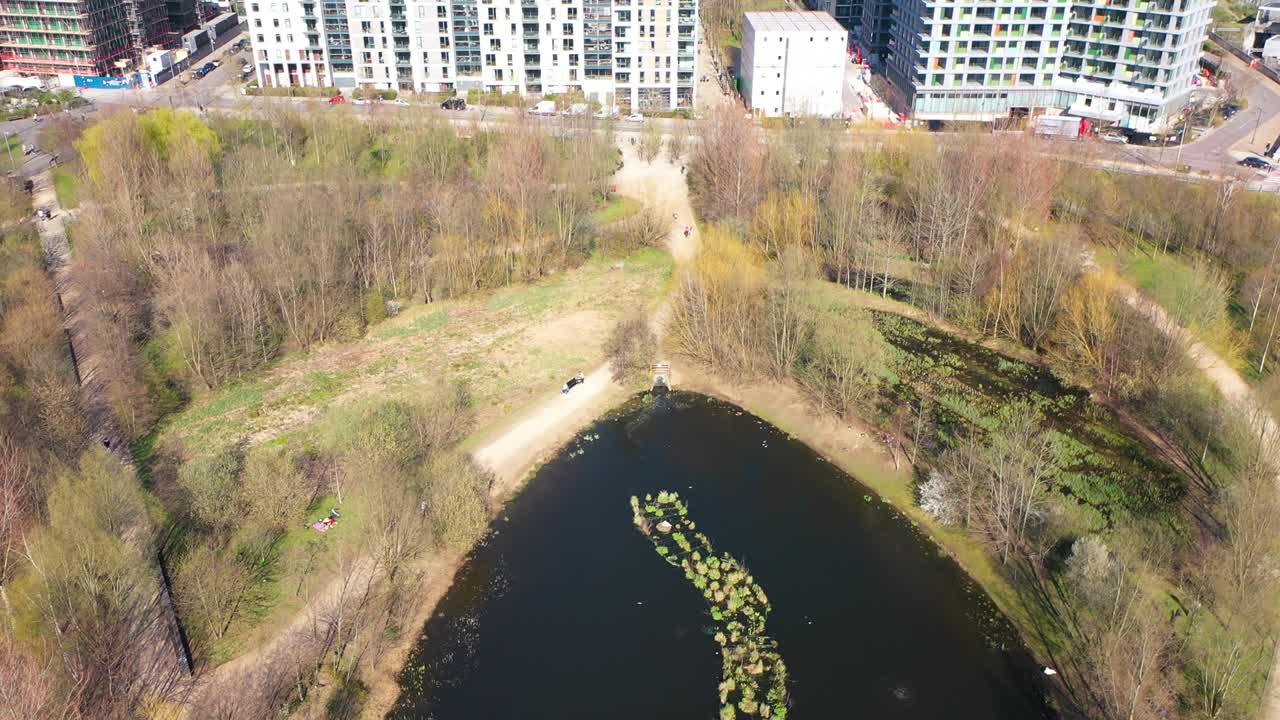 небольшой пруд в середине общественного парка с красивым городским пейзажем на заднем плане весной воздушные кадры из олимпийского парка королевы елизаветы