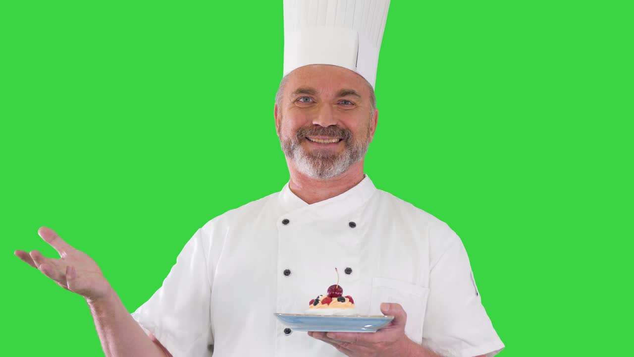 chef poniendo cereza en la parte superior del pastel antes de servirlo cereza en el pastel en una pantalla verde, llave de croma