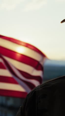 silhouette of a soldier salutes in front of the american flag memorial day
