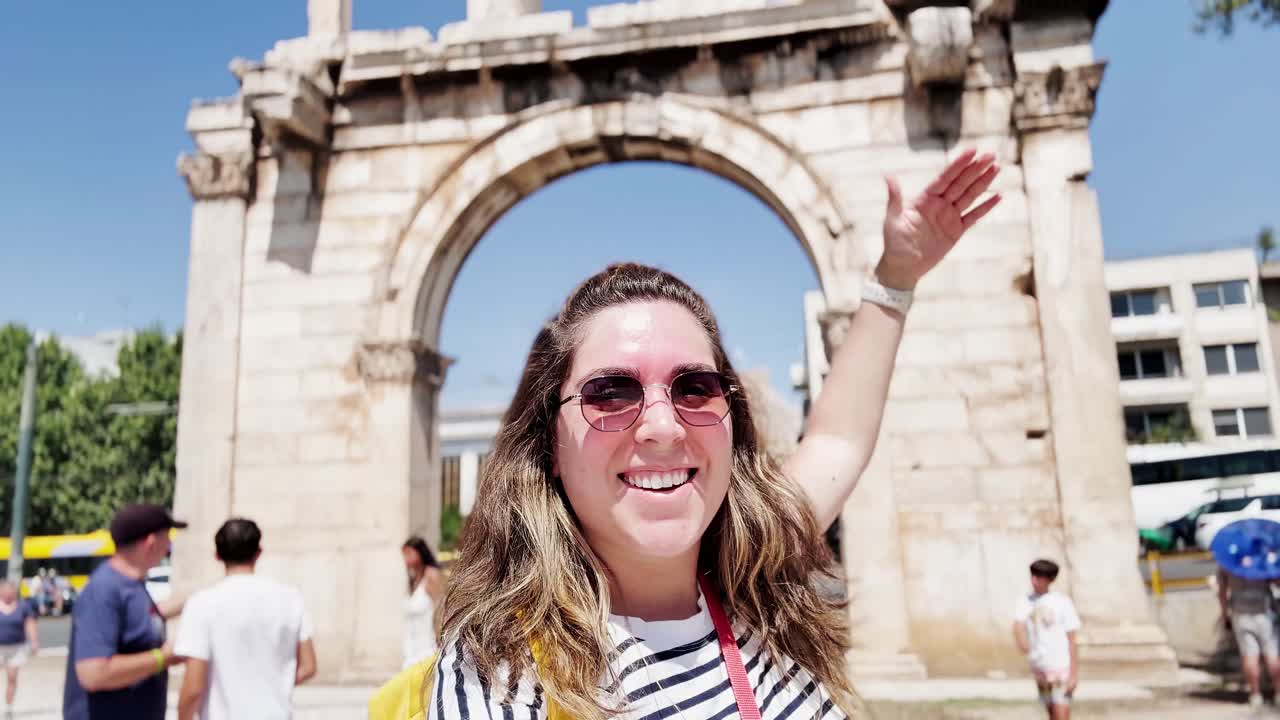 Donna gioiosa che saluta per un selfie presso un punto di riferimento greco, Atene, Grecia