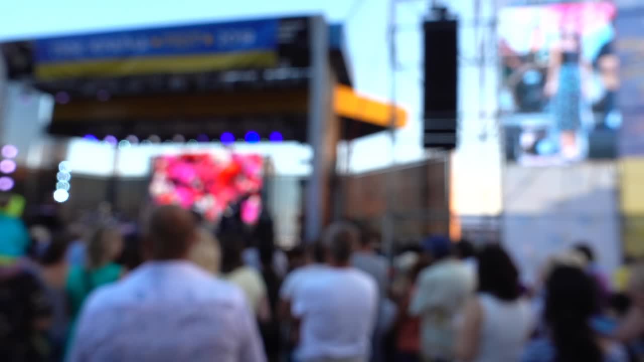 Concerto sul palco. Folla di persone e musicisti sulla scena. Fuori fuoco