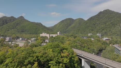 toma aérea corta que revela hermosos paisajes montañosos en la famosa ciudad de onsen de aguas termales jozankei hokkaido, japón