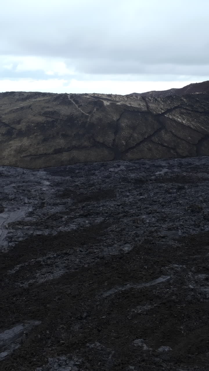 Aerial View of Vast Volcanic Lava Field and Mountain