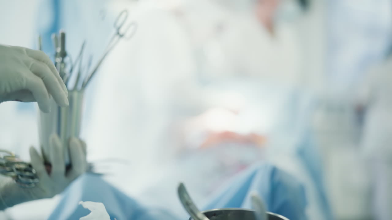 las manos de la enfermera de lavado toman herramientas estériles. la trabajadora responsable prepara los instrumentos necesarios para ayudar a los cirujanos durante la cirugía en la sala de operaciones