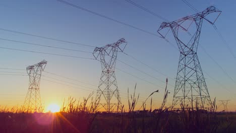 Tiempo-Transcurrido-De-Torre-De-Electricidad-En-Un-Campo-Durante-La-Puesta-De-Sol-4k