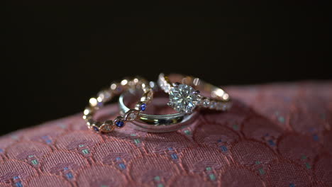 close up of three wedding rings with precious gems