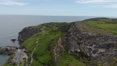 Aerial-footage-of-large-rocky-and-grass-mountain,-panoramic-view-of-mountain-by-the-sea