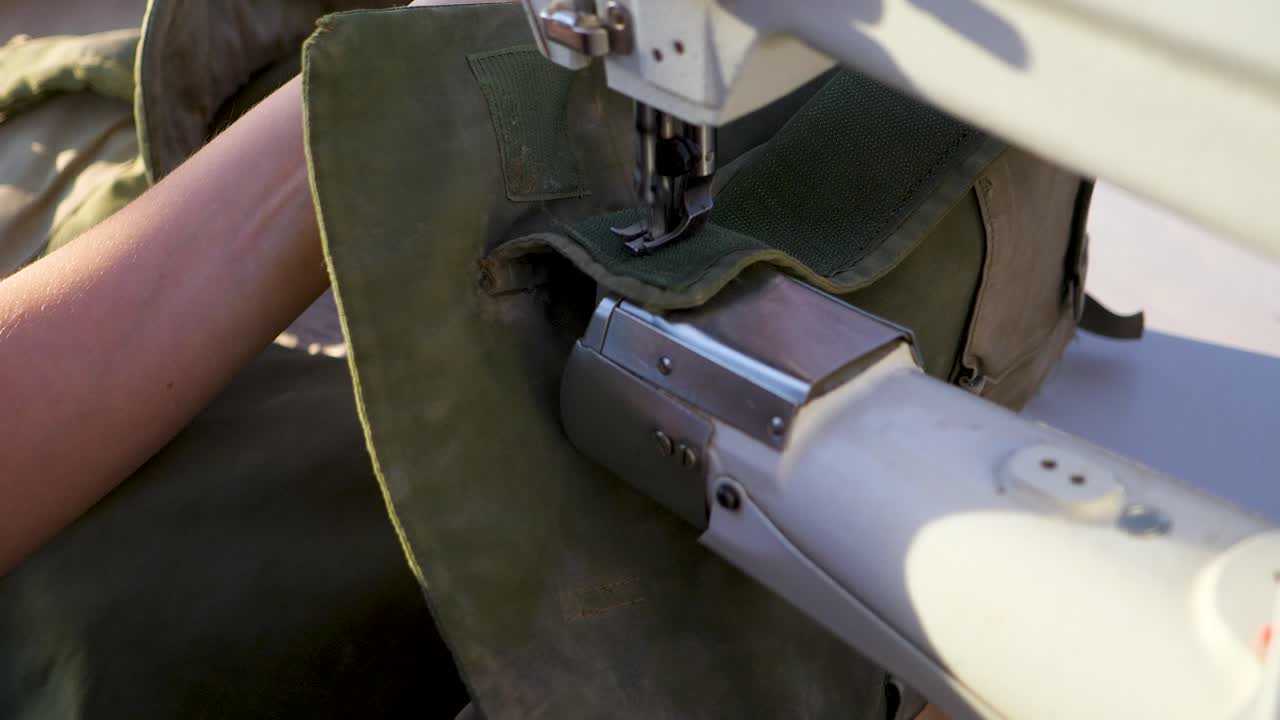 Close up sewing torn Israeli IDF soldier's clothes