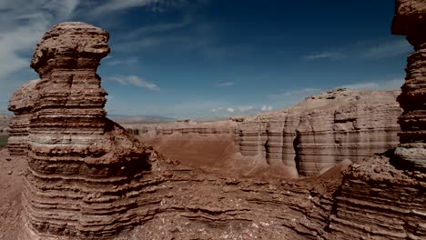 an eroded sandstone canyon and cliffs in a desert environment - pullback aerial reveal