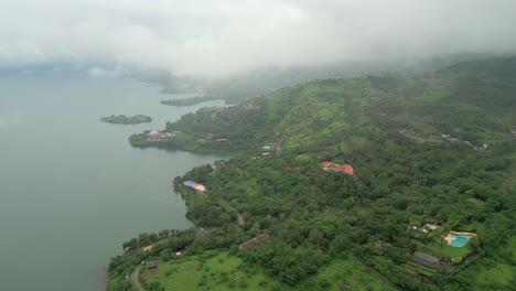 greenery hill station and small village in near pawana lake drone view from dark clouds