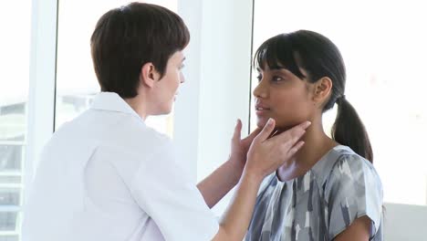 female doctor examining a patients throat