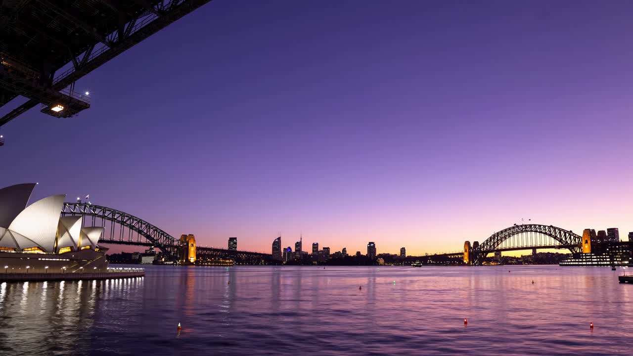 Video grandangolare della Sydney Opera House e dell'Harbour Bridge al crepuscolo, che cattura la serenità dell'acqua