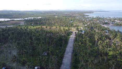 Carretera-Costera-A-Lo-Largo-De-Pueblos-Pesqueros-En-La-Isla-Tropical-De-Siargao,-Vista-De-Drones