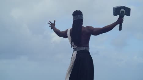 the tropical beach showcases a muscular, dark-skinned man perfectly portraying nekharis in cosplay