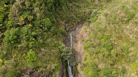 Aerial-reveal-of-Kitekite-Falls-and-hidden-pool,-New-Zealand