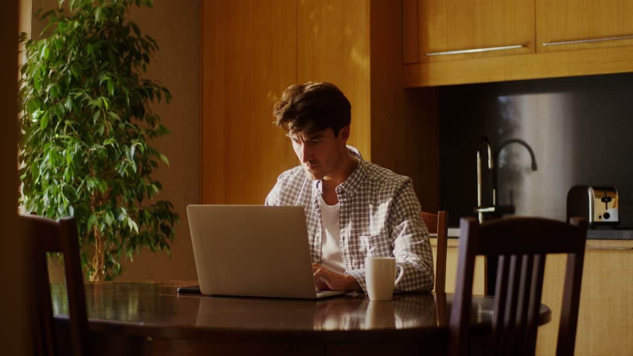Man working on a laptop in a kitchen