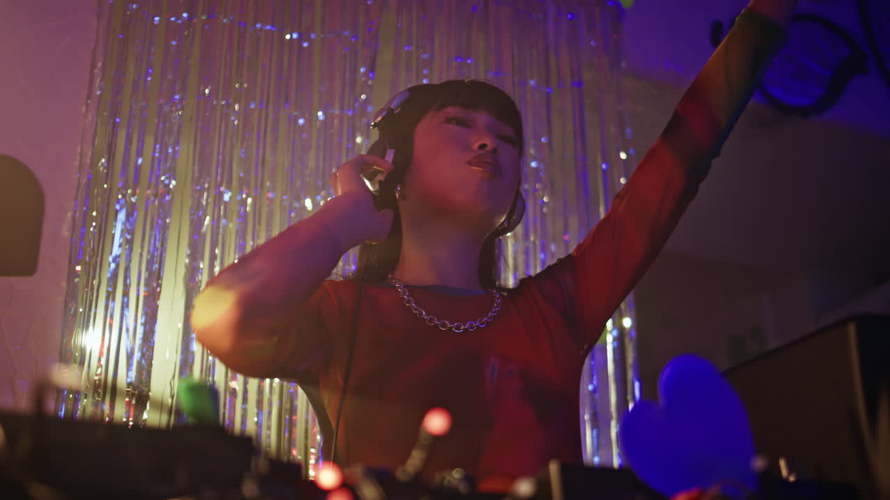 Girl DJ enjoy party wearing headphones immersed in nightclub music closeup