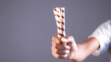 hand holding chocolate covered wafer sticks