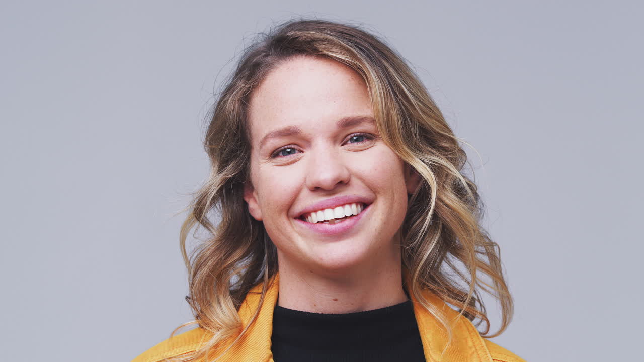 Close Up Head And Shoulders Studio Shot Of Woman Laughing At Camera In Slow Motion