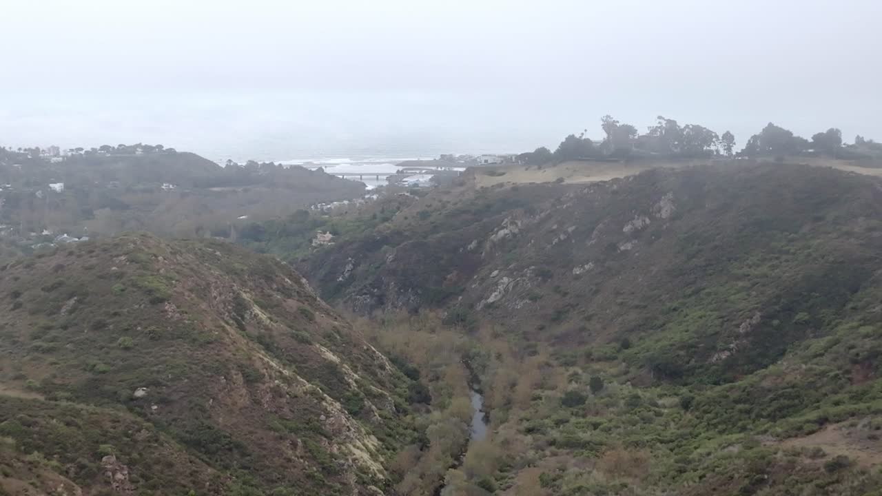 las montañas de santa mónica en malibú, california con el océano pacífico en la distancia y el video de drones avanzando