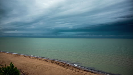 Ocean-waves-crash-on-sandy-shore-as-thin-clouds-bundle-and-move-in-sky-time-lapse