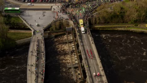 drone top down rotate and descend around parade floats and people gathering outside of galway cathedral