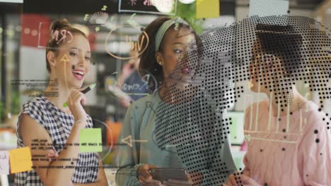 animation of globe and data processing over diverse women discussing over glass board at office