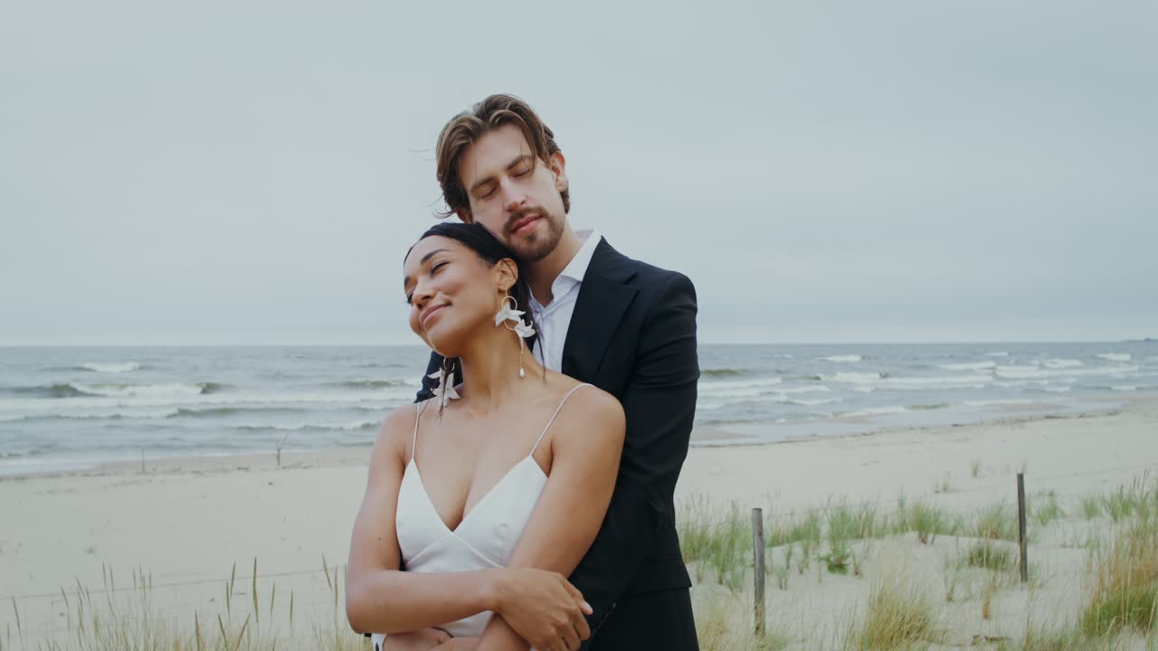 Casal romântico de noivos se abraçando na praia