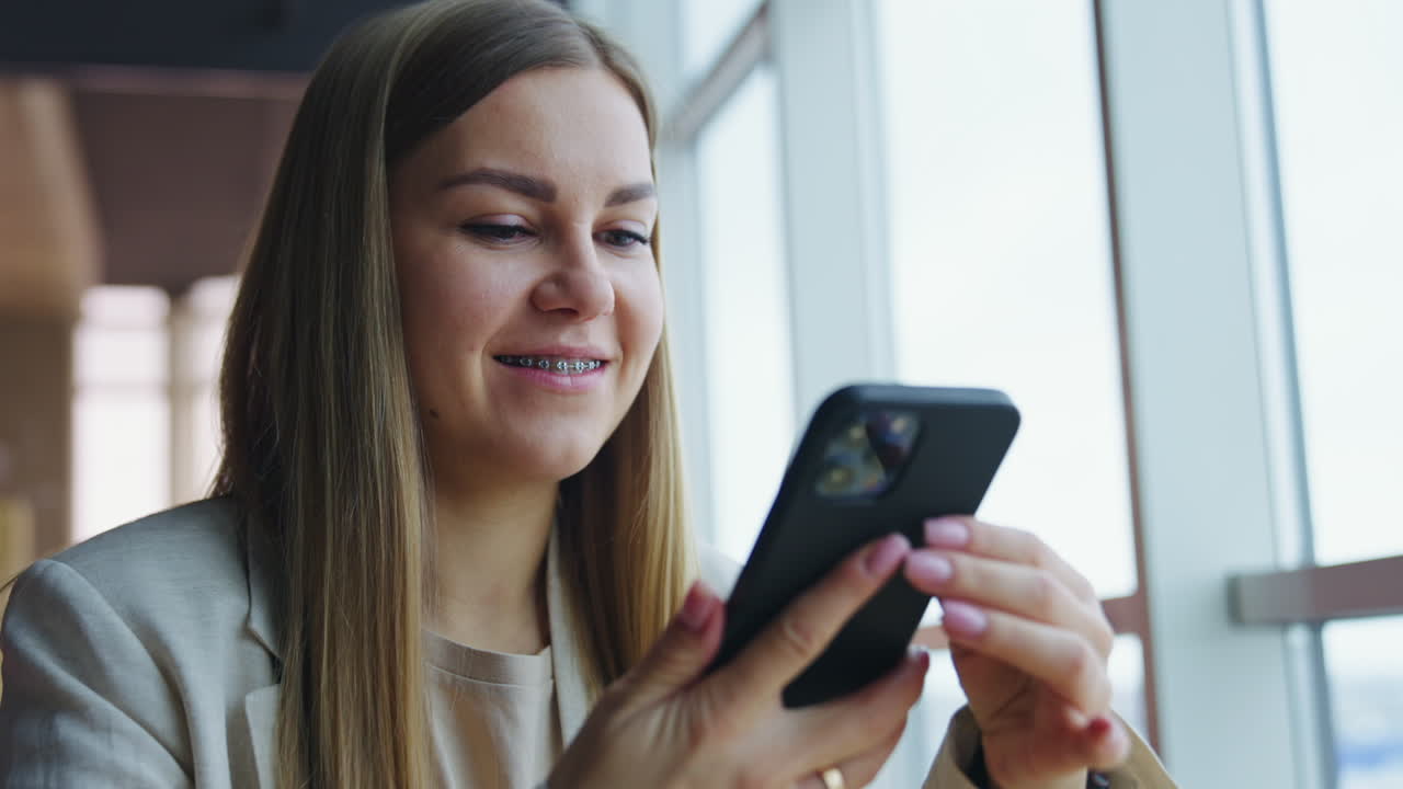Young lady starting conversation on the phone. Woman speaking on the phone and drinking tea. Close up.